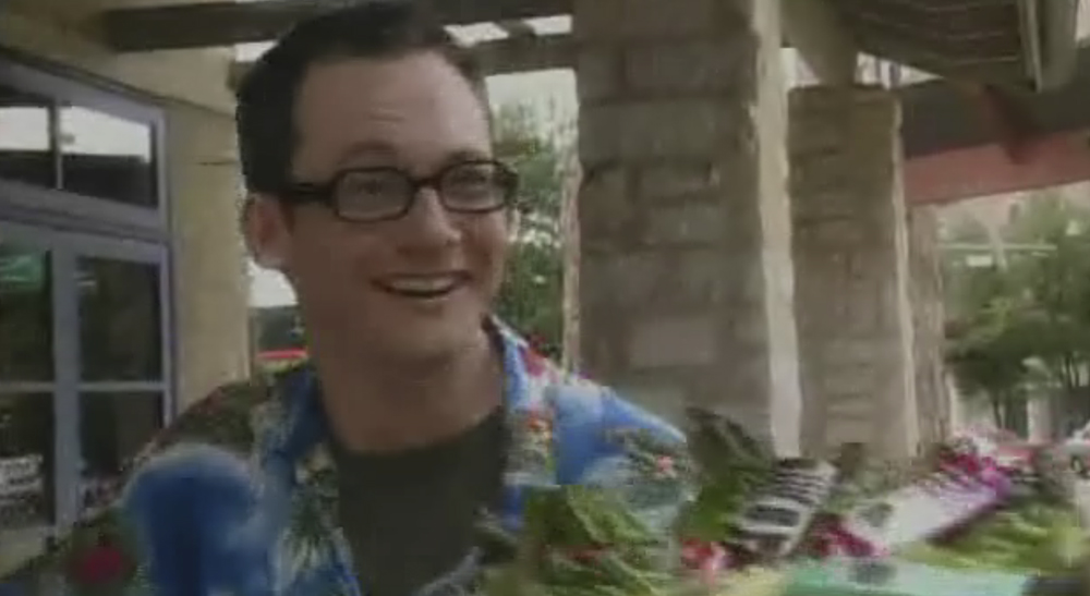 A man in glasses and hawaiian shirt smiling.